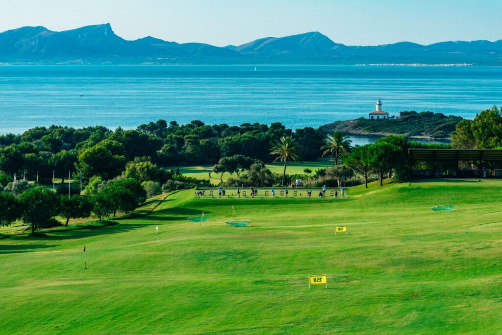 Grupo de jugadores en tee de prácticas Alcanada Golf